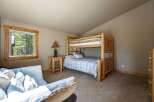 This charming bedroom features a rustic log bunk bed, perfect for accommodating guests or family.