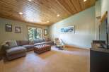This spacious living room features a large sectional sofa complemented by a plush leather ottoman, perfect for relaxation and entertaining.