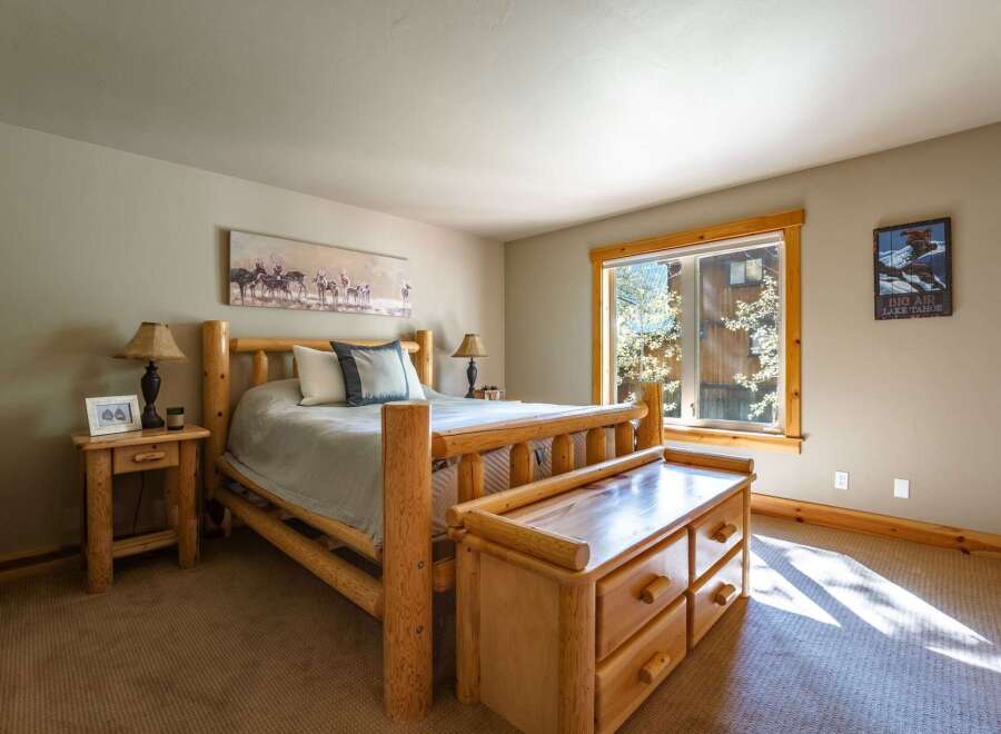 Experience rustic charm in this cozy bedroom, featuring a beautiful log bed and a matching wooden dresser.