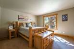 Experience rustic charm in this cozy bedroom, featuring a beautiful log bed and a matching wooden dresser.