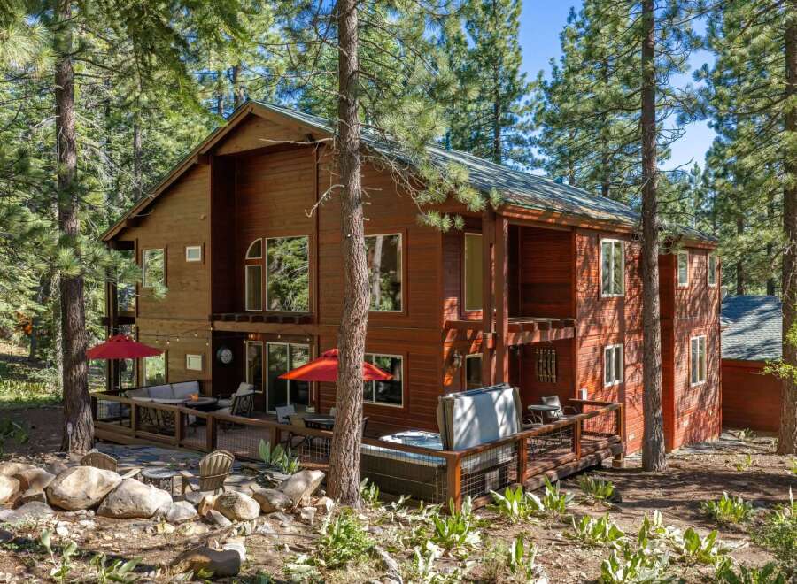 Escape to this stunning multi-level wooden home nestled amongst tall pine trees, offering a serene mountain retreat.