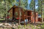 Escape to this stunning multi-level wooden home nestled amongst tall pine trees, offering a serene mountain retreat.