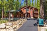 Nestled amidst towering pine trees, this stunning wooden home offers a serene mountain retreat.