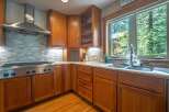 This beautifully appointed kitchen features warm cherry wood cabinetry and a sleek stainless steel range hood.