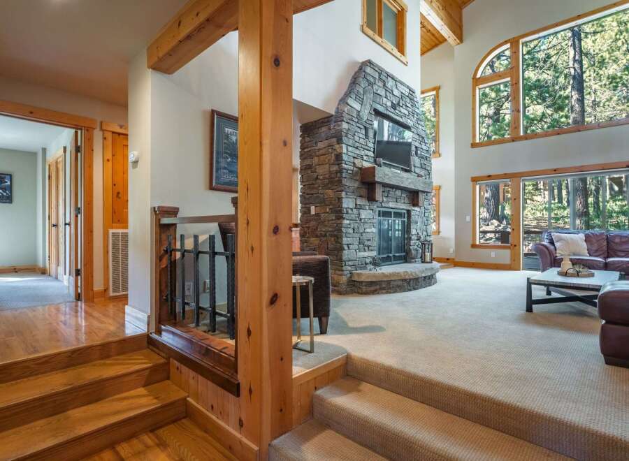 Experience rustic luxury in this stunning mountain home, featuring a grand stone fireplace as the centerpiece of the living area.