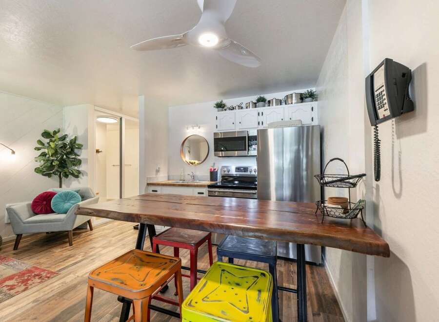 Experience comfortable living in this charming studio apartment, featuring a live-edge dining table perfect for meals or work.