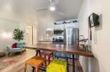 Experience comfortable living in this charming studio apartment, featuring a live-edge dining table perfect for meals or work.