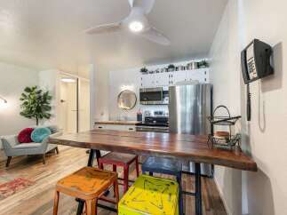 Experience comfortable living in this charming studio apartment, featuring a live-edge dining table perfect for meals or work.