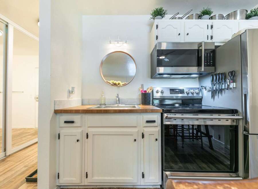 Discover this charming kitchen featuring a sleek stainless steel microwave and a modern electric range, perfect for culinary adventures.