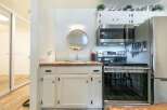 Discover this charming kitchen featuring a sleek stainless steel microwave and a modern electric range, perfect for culinary adventures.