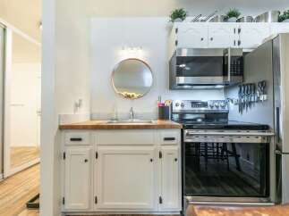 Discover this charming kitchen featuring a sleek stainless steel microwave and a modern electric range, perfect for culinary adventures.