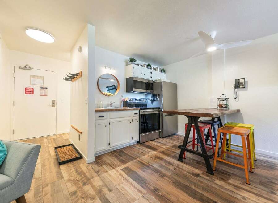 Discover this charming studio apartment featuring a compact yet functional kitchen with stainless steel appliances and ample cabinet space.