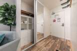 Discover smart storage solutions in this inviting space, featuring a mirrored closet and a built-in shelving unit perfect for organizing kitchenware.