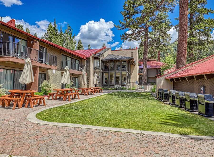 Enjoy outdoor living at this property featuring multiple picnic tables and umbrellas, perfect for al fresco dining.