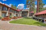Enjoy outdoor living at this property featuring multiple picnic tables and umbrellas, perfect for al fresco dining.