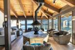 Experience breathtaking lake and mountain views from this stunning living area, featuring a modern fireplace as the centerpiece.