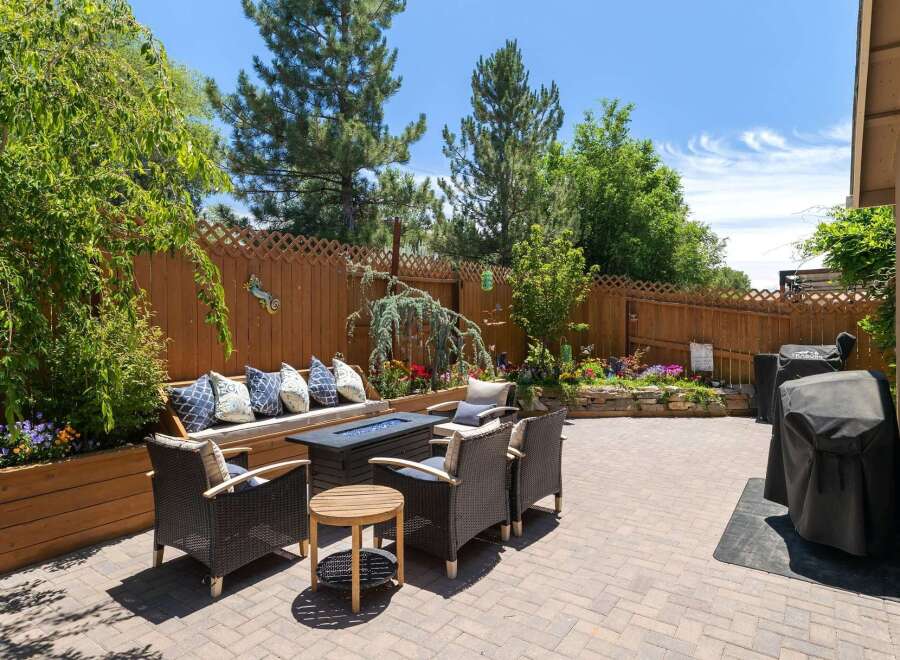 Enjoy outdoor living in this beautifully landscaped backyard featuring a cozy seating area with a fire pit, perfect for evening gatherings.