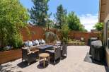 Enjoy outdoor living in this beautifully landscaped backyard featuring a cozy seating area with a fire pit, perfect for evening gatherings.