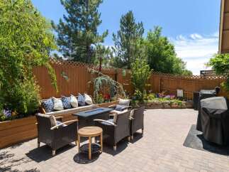Enjoy outdoor living in this beautifully landscaped backyard featuring a cozy seating area with a fire pit, perfect for evening gatherings.