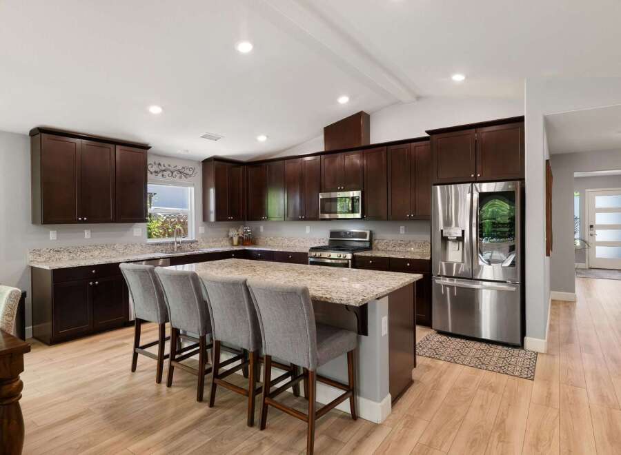 Experience luxury and functionality in this stunning modern kitchen, featuring rich espresso cabinetry and gleaming granite countertops.