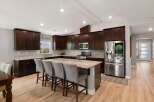 Experience luxury and functionality in this stunning modern kitchen, featuring rich espresso cabinetry and gleaming granite countertops.