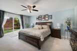 Experience luxurious comfort in this master bedroom, featuring a spacious king-size bed with elegant bedding and a rich, dark wood frame.