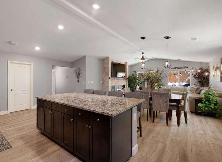 This spacious open-concept living area features a large kitchen island with granite countertops, perfect for entertaining.