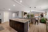 This spacious open-concept living area features a large kitchen island with granite countertops, perfect for entertaining.