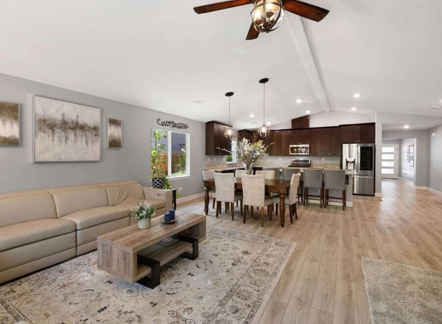Experience open-concept living in this beautifully appointed home, featuring a spacious living area flowing seamlessly into a modern kitchen and dining space.