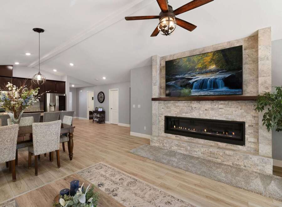 Experience modern living in this spacious open-concept home, featuring a stunning stone fireplace as the centerpiece of the living area.