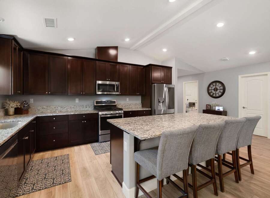 Experience luxury in this stunning kitchen featuring rich, dark wood cabinetry and sleek granite countertops.