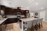 Experience luxury in this stunning kitchen featuring rich, dark wood cabinetry and sleek granite countertops.
