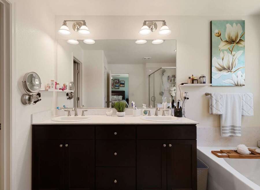 Indulge in luxury with this stunning bathroom featuring a spacious double vanity with marble countertops and dark wood cabinetry.