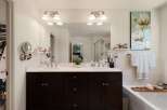 Indulge in luxury with this stunning bathroom featuring a spacious double vanity with marble countertops and dark wood cabinetry.