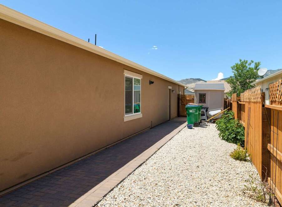 Discover this charming property featuring a well-maintained backyard with a paved walkway and gravel landscaping.