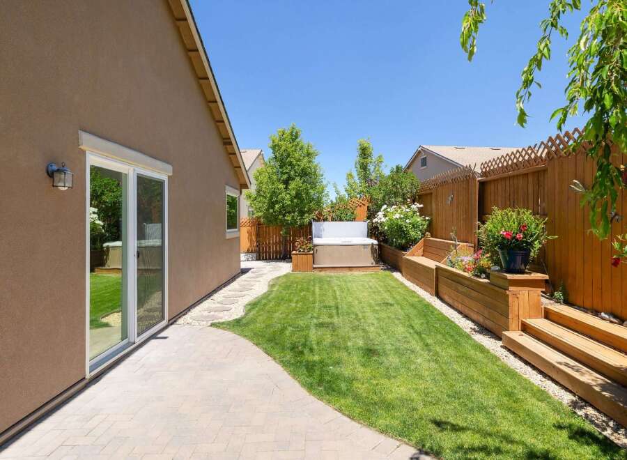 Enjoy outdoor living in this beautifully landscaped backyard featuring a relaxing hot tub perfect for unwinding.