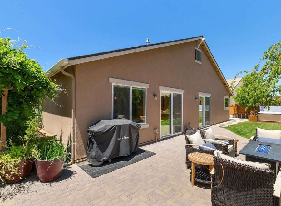 Enjoy outdoor living with this spacious patio featuring a covered grill and comfortable seating area, perfect for entertaining.