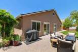 Enjoy outdoor living with this spacious patio featuring a covered grill and comfortable seating area, perfect for entertaining.