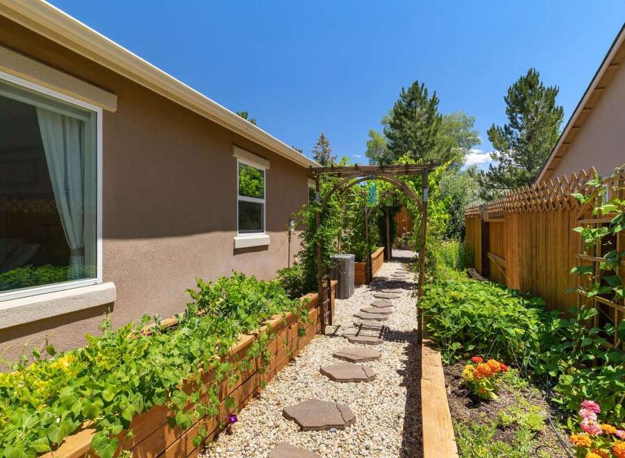 Discover this charming backyard oasis featuring a picturesque stone pathway leading through a lush garden.