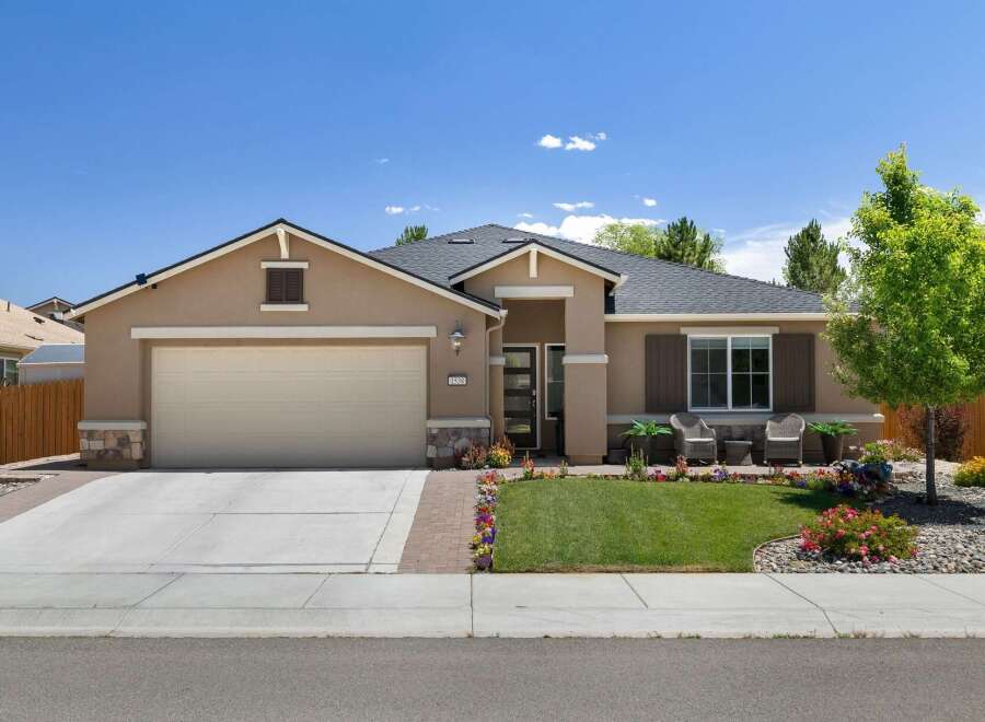 This charming single-family home features a welcoming facade with a neutral-toned stucco exterior and stone accents.