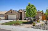Discover this charming single-story home featuring a welcoming facade with a well-maintained lawn and vibrant flower beds.
