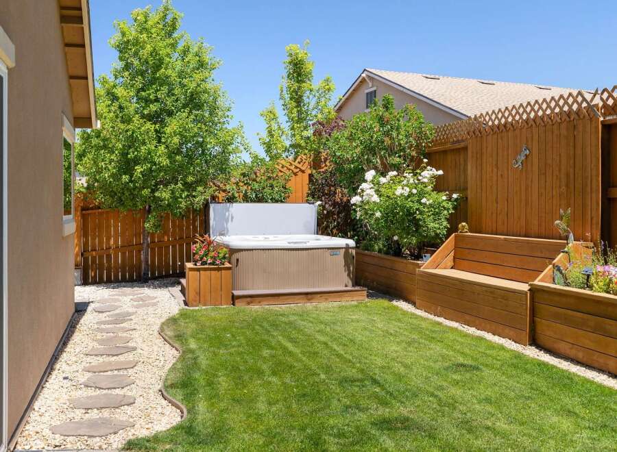 Escape to your private backyard oasis featuring a luxurious hot tub perfect for relaxation.