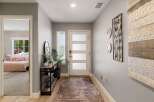 Step into this welcoming entryway featuring a modern door with frosted glass panels, leading into a bright and airy hallway.