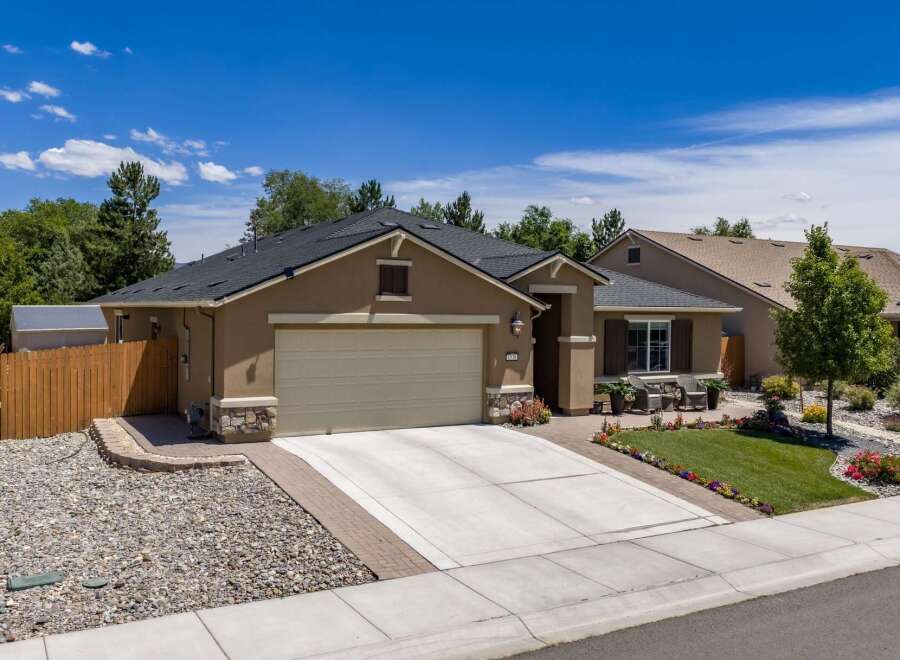 Discover this charming single-story home featuring a welcoming facade with stone accents and a spacious driveway leading to an attached garage.