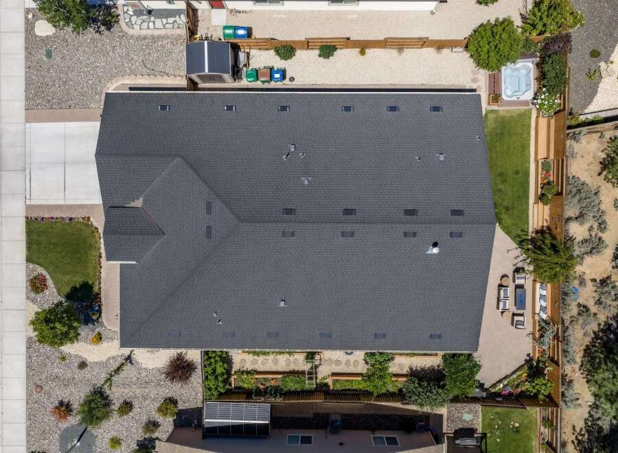 Discover this stunning property featuring a spacious, dark gray asphalt shingle roof, perfect for any home.