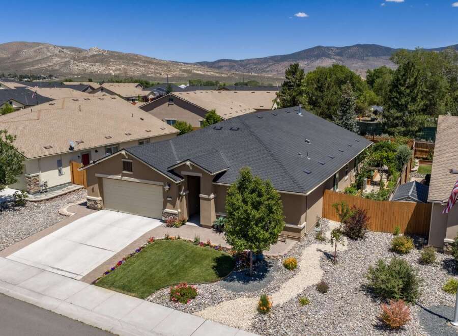 Discover this charming single-family home featuring a spacious two-car garage and a beautifully landscaped front yard with vibrant flowers and a lush green lawn.