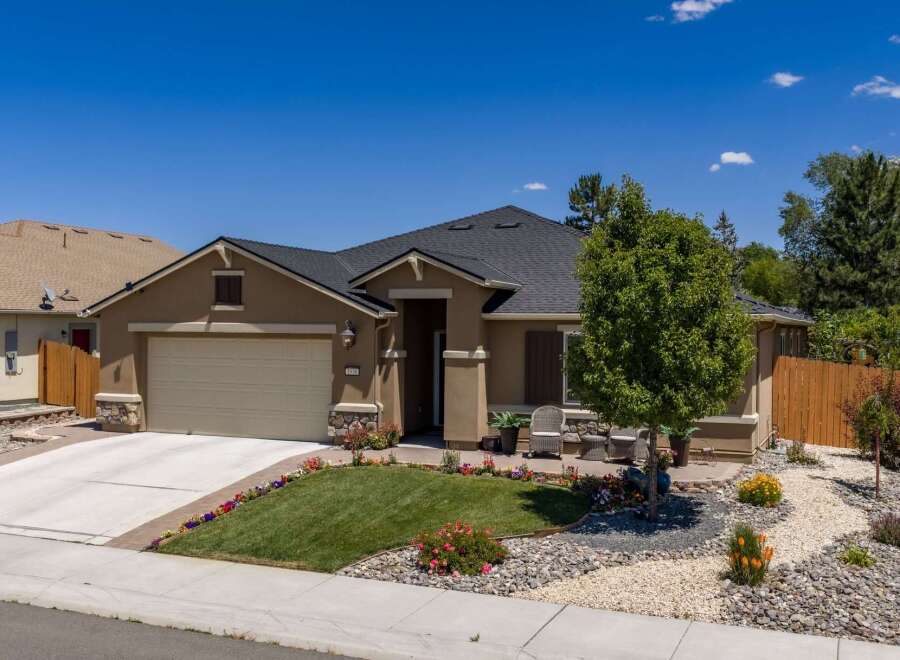 Discover this charming single-story home featuring a well-maintained lawn and vibrant flower beds.
