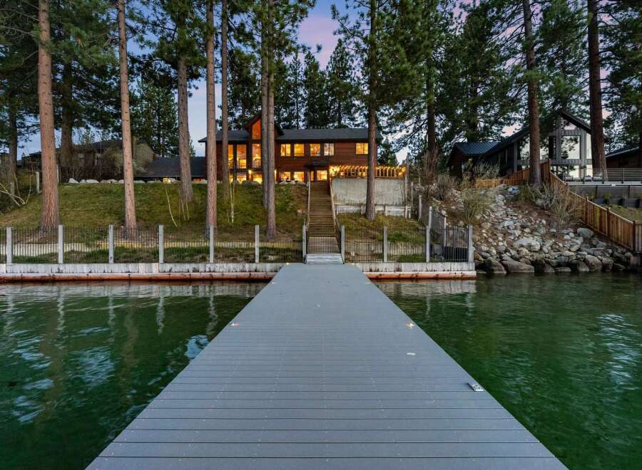 Experience luxury lakeside living with this stunning property featuring a modern dock extending into the serene waters.
