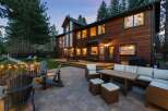 Experience luxurious outdoor living with this stunning property featuring a spacious wooden deck and a stone patio perfect for entertaining.
