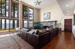 Experience breathtaking lake views from this stunning living room, featuring a massive stone fireplace and expansive windows that bring the outdoors in.